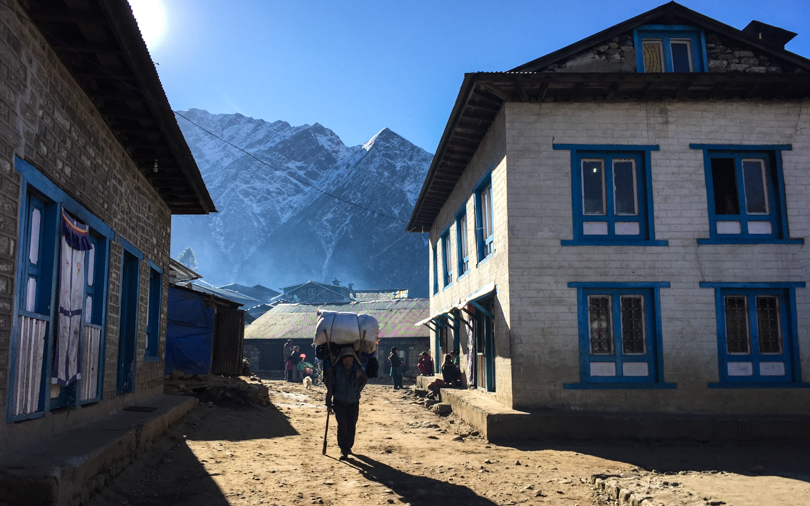 Local carrying heavy supplies in one of the villages